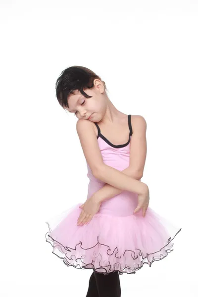 Söt liten balettdansös med vackra hår står i en balett pose — Stockfoto