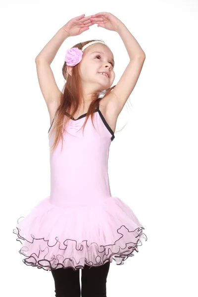 Portrait of a smiling little dancer in pink tutu standing in a ballet pose — Stock Photo, Image