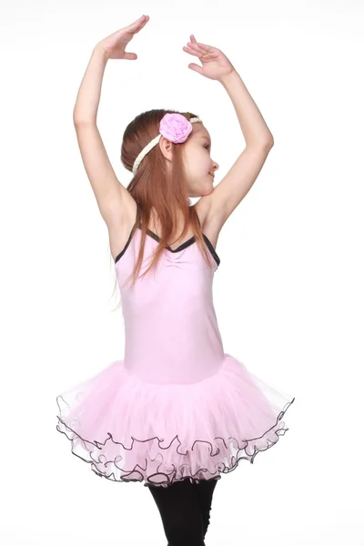 Fröhlich lächelndes kleines Mädchen in einem Tutu, das auf isoliertem Weiß über Schönheit und Mode tanzt — Stockfoto