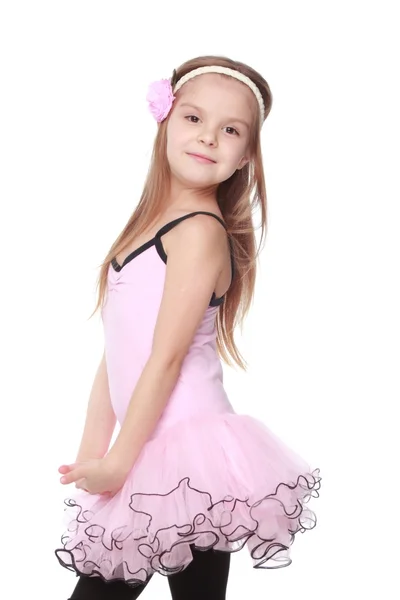 Элегантный танцор в костюме балерины Студийный образ очаровательной танцовщицы с красивыми волосами в розовой пачке, улыбающейся и танцующей на белом фоне — стоковое фото