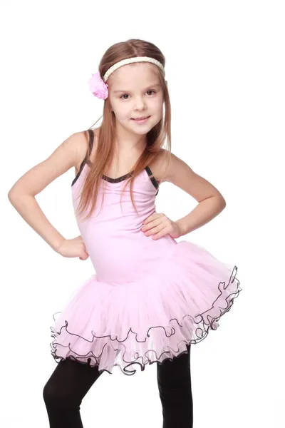 Студийный портрет красивой маленькой балерины в розовой пачке в танцевальной позе на белом фоне — стоковое фото