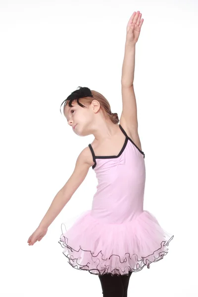 Studio image of a charming dancer with beautiful hair in a pink tutu smiling and dancing on white background — Stock Photo, Image