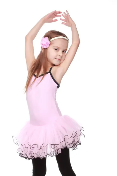 粉色的芭蕾舞裙站在芭蕾舞姿微笑着的小舞者的肖像 — 图库照片