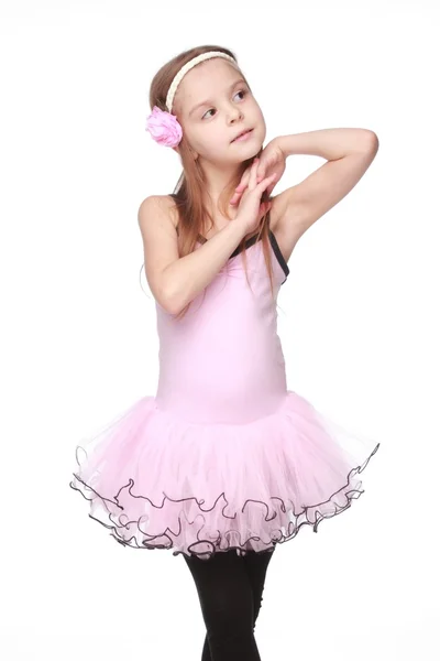 Portrait of a smiling little dancer in pink tutu standing in a ballet pose — Stock Photo, Image