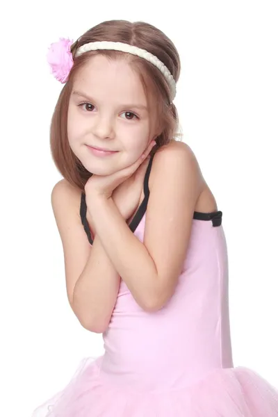 Portret van een glimlachende weinig danser in roze tutu staande in een ballet pose — Stockfoto