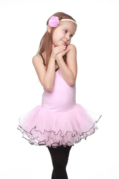 Studio image of a charming dancer with beautiful hair in a pink tutu smiling and dancing on white background — Stock Photo, Image