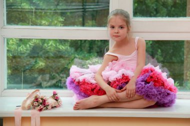 pointe Ayakkabı ve çiçeklerle bir pencere kenarında oturan sevimli küçük kız