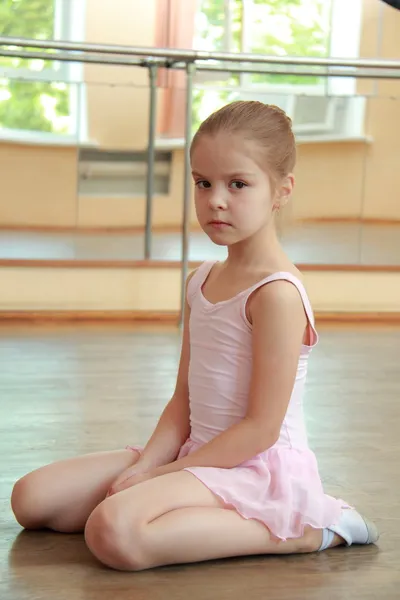 Kaukasische ballerina aan het warmrijden in pointe in de ballet hal op de houten dansvloer — Stockfoto