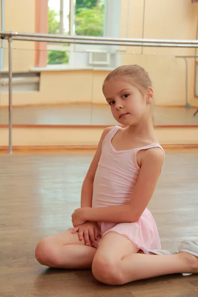 Caucasian ballerina warming up in pointe in the ballet hall on the wooden dance floor — Stock Photo, Image