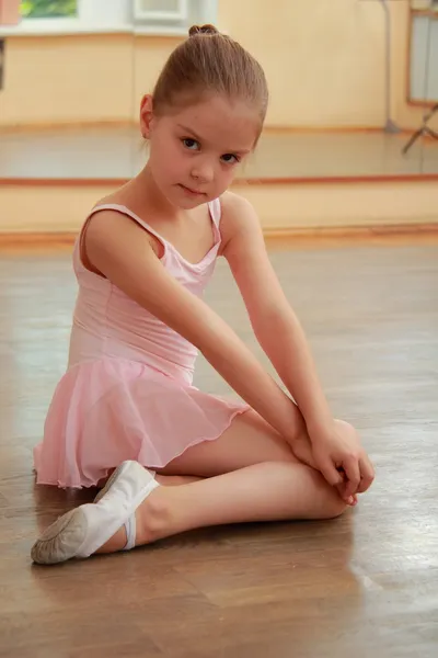 Smiling ballerina in a tutu and pointe posing for the camera in a ballet class — Stock Photo, Image
