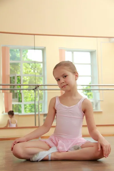 Kaukasische ballerina aan het warmrijden in pointe in de ballet hal op de houten dansvloer — Stockfoto