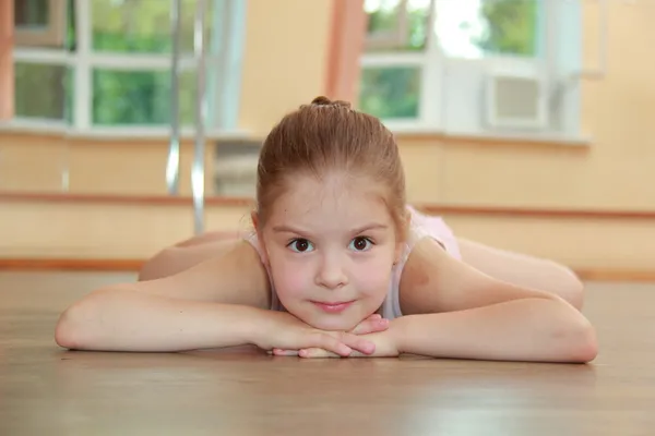Chica joven dedicada a un tutú de ballet rosa y puntas en la sala de ballet en la pista de baile de madera —  Fotos de Stock