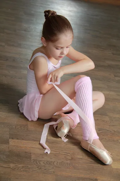 Joven bailarina pone en punta en la clase de ballet en la vieja pista de baile de madera — Foto de Stock