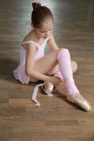 Young ballerina puts on pointe in ballet class at the old wooden dance floor — Stock Photo, Image