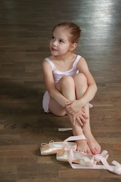 Junge Ballerina legt im Ballettkurs auf der alten hölzernen Tanzfläche auf — Stockfoto