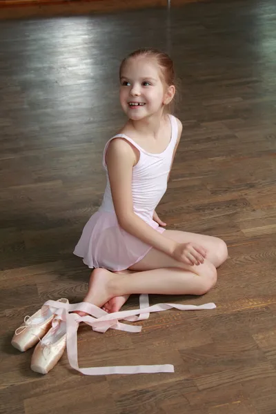 Caucasian ballerina warming up in pointe in the ballet hall on the wooden dance floor — Stock Photo, Image