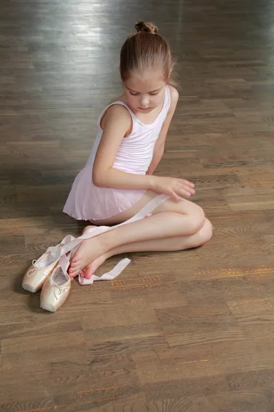 Joven bailarina pone en punta en la clase de ballet en la vieja pista de baile de madera — Foto de Stock