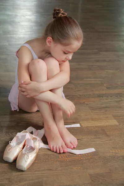 Jong meisje die zich bezighouden met een roze ballet tutu en pointe in de ballet hal op de houten dansvloer — Stockfoto