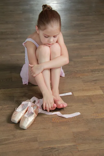 Young ballerina puts on pointe in ballet class at the old wooden dance floor — Stock Photo, Image