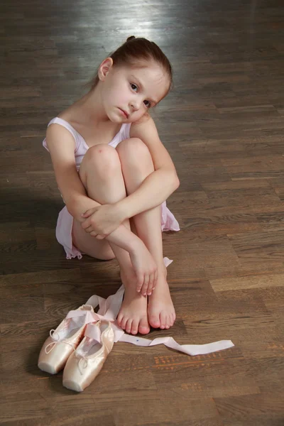 Bailarina caucasiana aquecendo em pointe no salão de balé na pista de dança de madeira — Fotografia de Stock