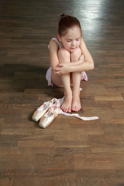 Jonge ballerina zet op pointe in ballet klas op de oude houten dansvloer — Stockfoto