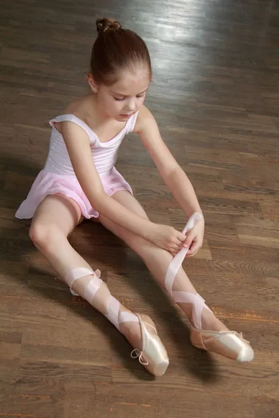 Sorrindo bailarina em um tutu e aponte posando para a câmera em uma classe de balé — Fotografia de Stock