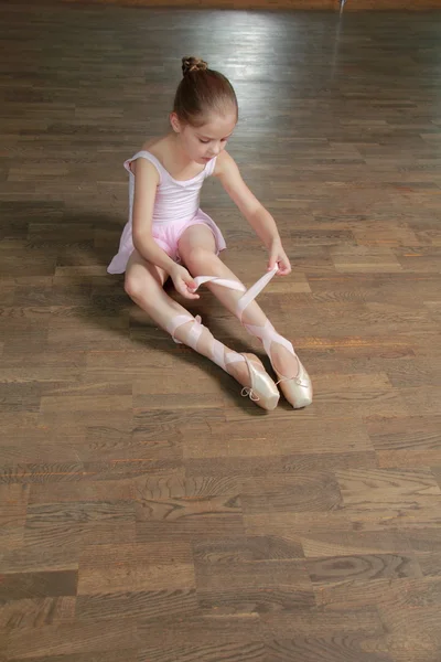 Joven bailarina pone en punta en la clase de ballet en la vieja pista de baile de madera —  Fotos de Stock