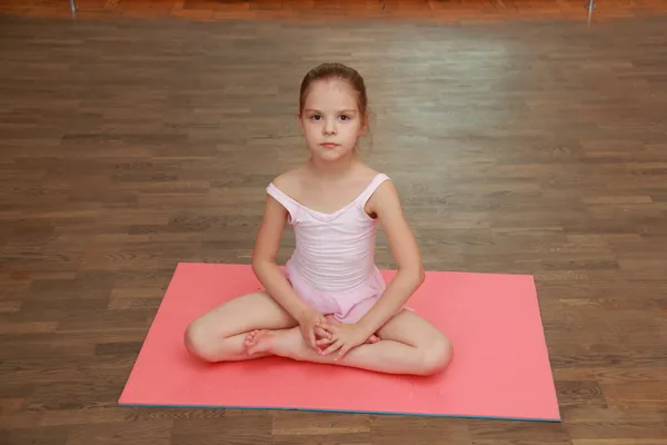 Lachende ballerina in een tutu en pointe poseren voor de camera in een ballet klas — Stockfoto