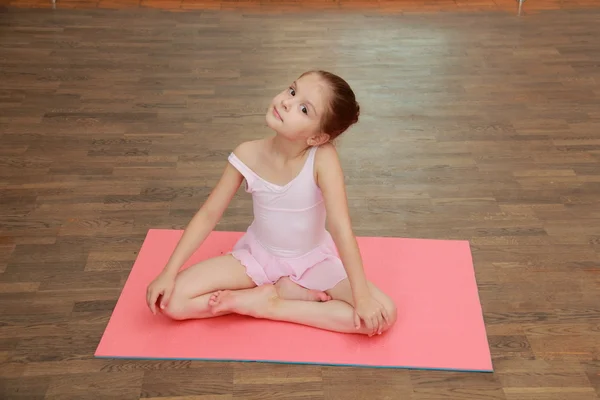 Little gymnast in a tracksuit and a gym shoes in gym class — Stock Photo, Image