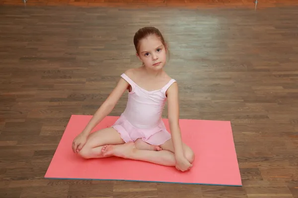 Bella bambina che fa esercizi sportivi sul tappeto (stretching ) — Foto Stock
