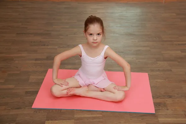 Little gymnast in a tracksuit and a gym shoes in gym class — Stock Photo, Image