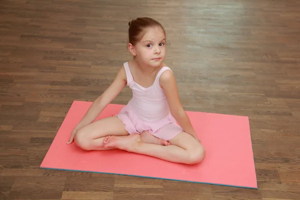 Belle petite fille faisant des exercices sportifs sur le tapis (étirement ) — Photo