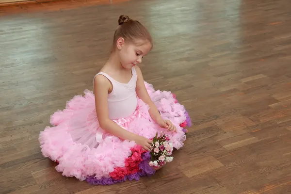 sevimli çocuk bir ahşap yerde oturan güzel yemyeşil dans etek