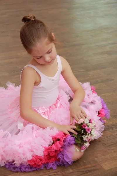 Smiling ballerina in a tutu and pointe posing for the camera in a ballet class — Stock Photo, Image