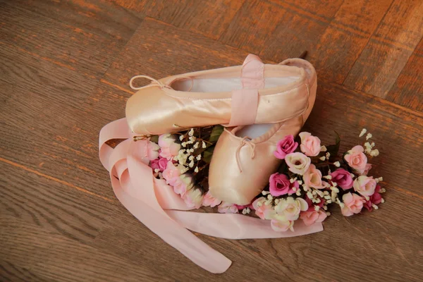 Used pointe shoes on a wooden surface — Stock Photo, Image