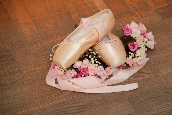 Chaussures Pointe avec rubans et bouquet de fleurs sur fond de vieux parquet — Photo