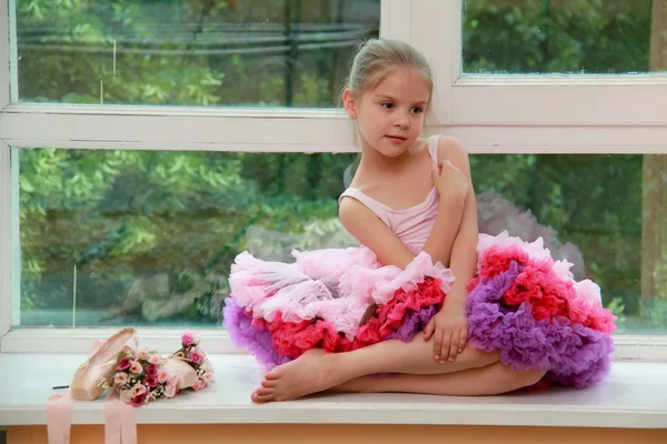 Gülümseyen genç balet pointe ayakkabılar ve bir pencere kenarında oturan çiçek — Stok fotoğraf