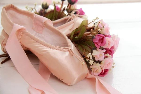 Pointe rose pour enfants avec des rubans posés sur le rebord de la fenêtre à côté de fleurs blanches — Photo