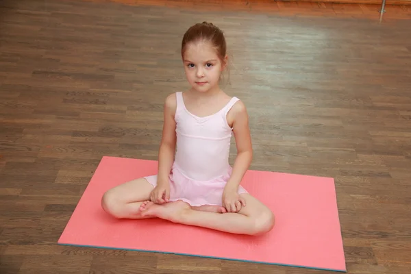 Härlig liten flicka göra sport övningar på matta (stretching) — Stockfoto