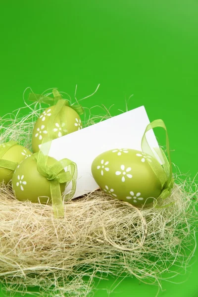 Colored egg with a pattern in the Easter basket and a blank sheet for greeting text — Stock Photo, Image