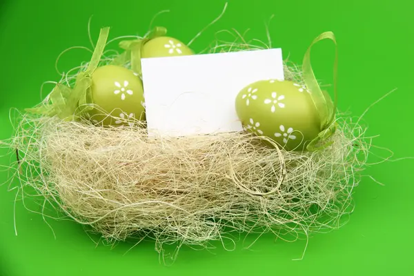 Green egg with a pattern in the Easter basket and a blank sheet for greeting text — Stock Photo, Image