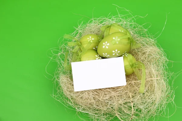 Colored egg with a pattern in the Easter basket and a blank sheet for greeting text — Stock Photo, Image
