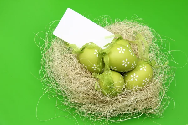 Green egg with a pattern in the Easter basket and a blank sheet for greeting text — Stock Photo, Image