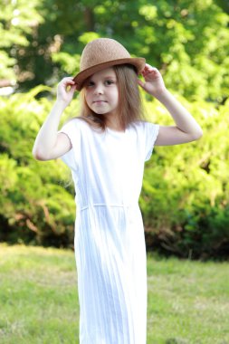 sevimli küçük kız yaz Park açık havada kameraya poz bir şapka ile