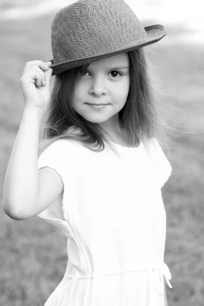Black and white portrait of a little girl with hat in retro style in a summer park outdoors — Stock Photo, Image
