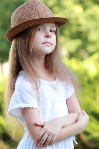 Kaukasisches lächelndes Mädchen in weißem Kleid und Hut im Freien — Stockfoto