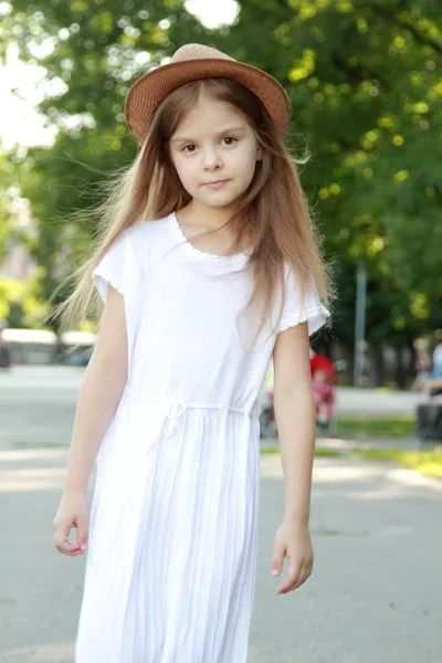 Belle petite fille dans une robe blanche et chapeau à l'extérieur — Photo