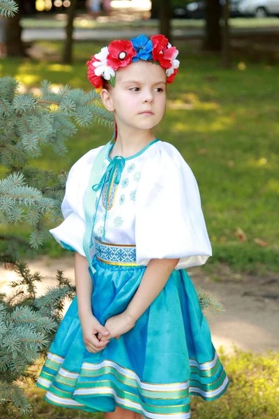 Uśmiechnięta dziewczynka w jasny kostium krajowego, Ukraina jest na tle zielonej trawie w parku lato — Zdjęcie stockowe