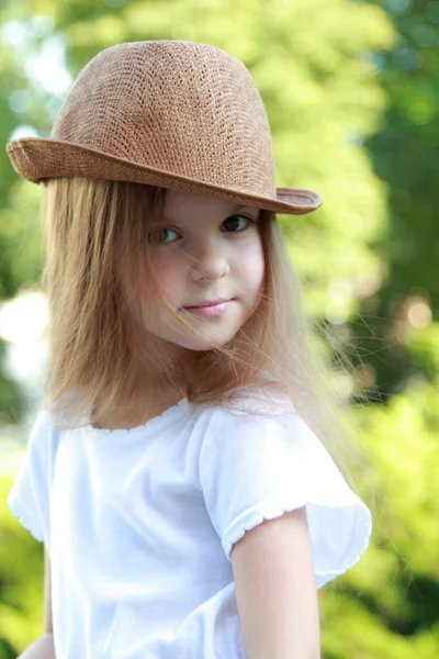 Happy little girl in a beautiful hat outdoors — Stock Photo, Image