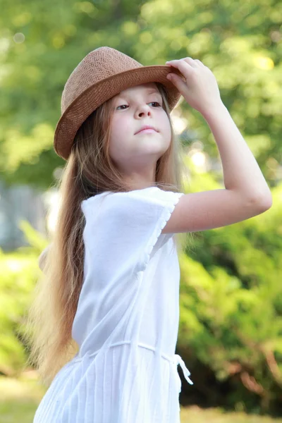 Glückliches kleines Mädchen mit einem schönen Hut im Freien — Stockfoto